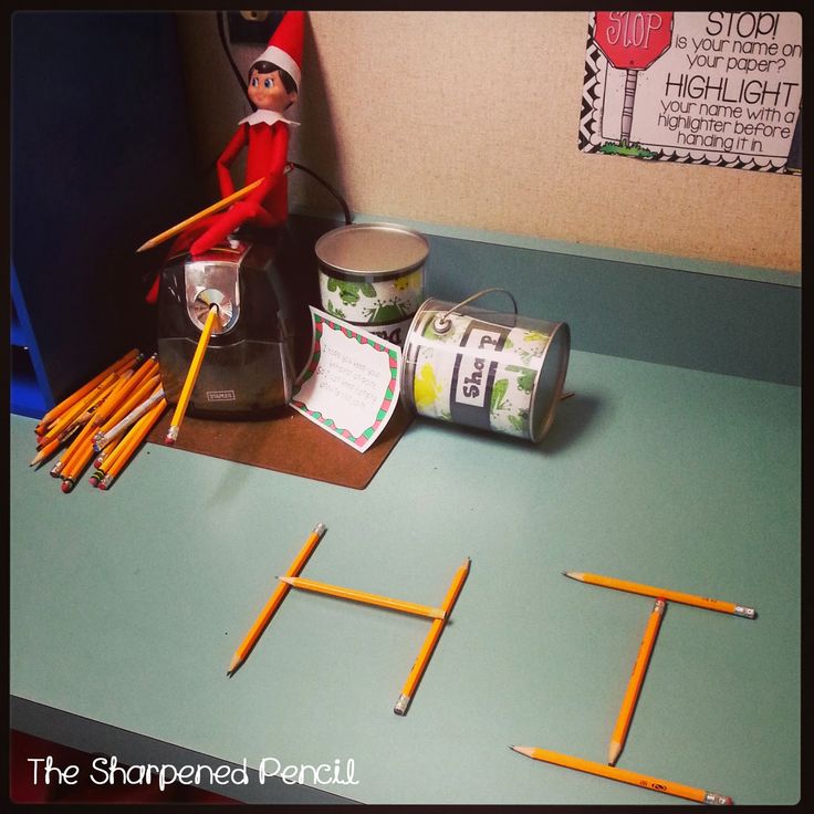 an elf is sitting on top of the desk with pencils and letters in front of him