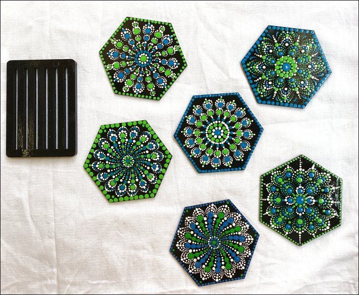 four different designs are shown on a white table cloth with a black object in the middle