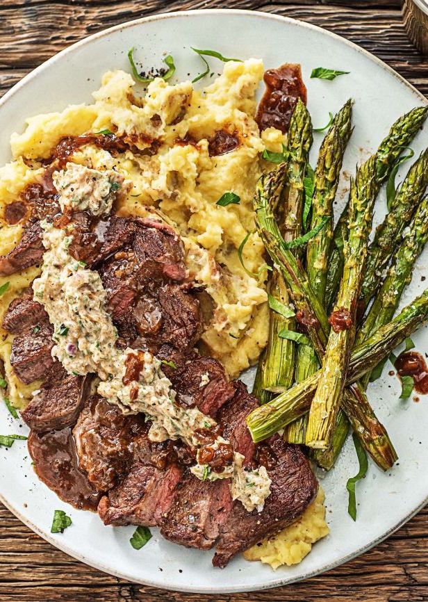 steak, mashed potatoes and asparagus on a white plate