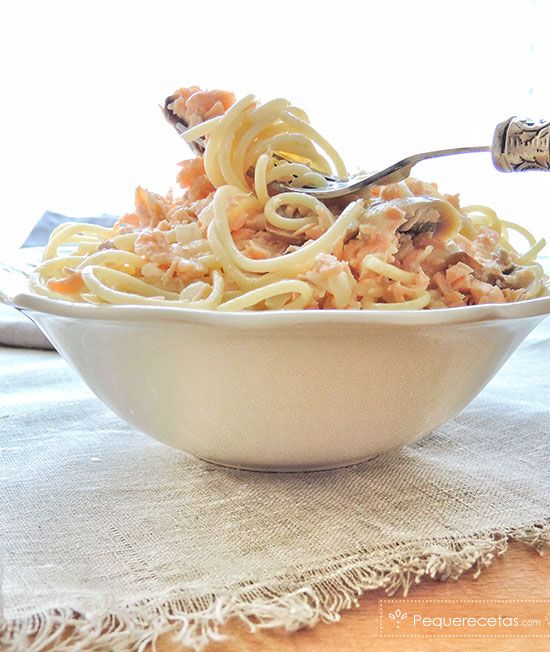 a white bowl filled with pasta on top of a table