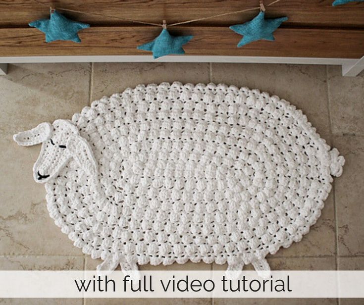 a crocheted sheep rug on the floor with text overlay that reads, with full video tutor