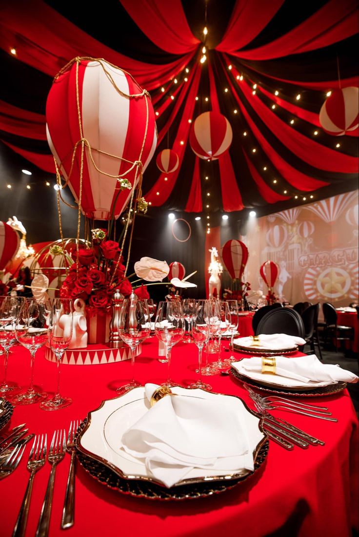 a table set with plates, silverware and hot air balloons