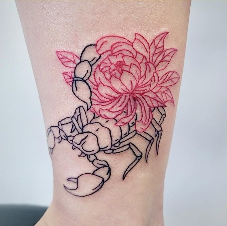 a woman's leg with a flower and crab tattoo on her left side ribcage