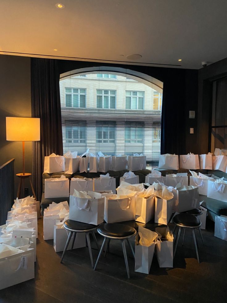 a room filled with bags and chairs next to a large window in front of a building