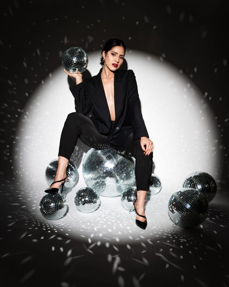 a woman sitting on top of shiny balls