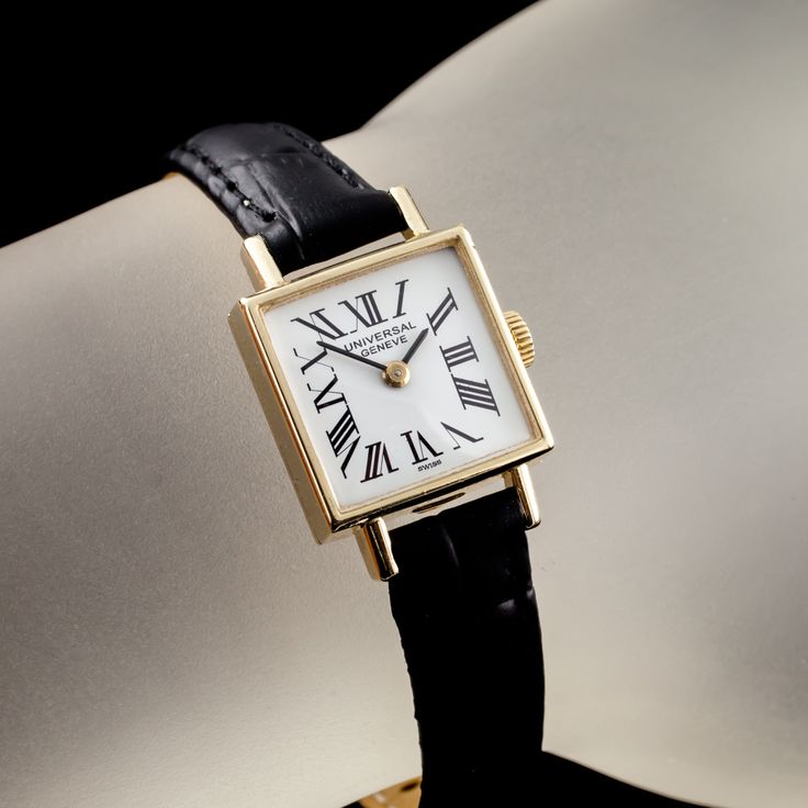 Movement #04 Case #4266-17134 14k Yellow Gold Square Case 17 mm Wide (18 mm w/ Crown) 16 mm Long Lug-to-Lug Distance = 24 mm Lug-to-Lug Width = 9 mm Thickness = 7 mm White Dial w/ Black Roman Numerals and Hands (M + H) Labeled "UNIVERSAL GENEVE / SWISS" 14 mm Wide 14 mm Long Black Leather Aftermarket Band w/ Gold-Plated Clasp Total Length = 7.5" Largest Wrist Fit = 6.5" Does Not Include Original Box or Papers This watch is guaranteed authentic. One year warranty included with purchase. Classic Watch With Box Clasp For Anniversary, Classic Engraved Business Watch, Classic Yellow Gold Watch Bands For Gifts, Classic Yellow Gold Watch Bands As Gift, Classic Yellow Gold Watch Accessories For Anniversary, Vintage Leather Strap Watch Bands For Formal Occasion, Vintage Leather Strap Watch Bands For Formal Wear, Timeless Leather Strap Watch Accessories For Anniversary, Classic Watch Bands For Anniversary