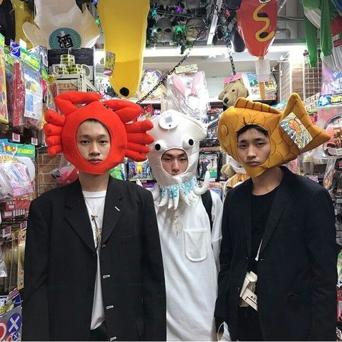 three young men standing next to each other wearing animal masks