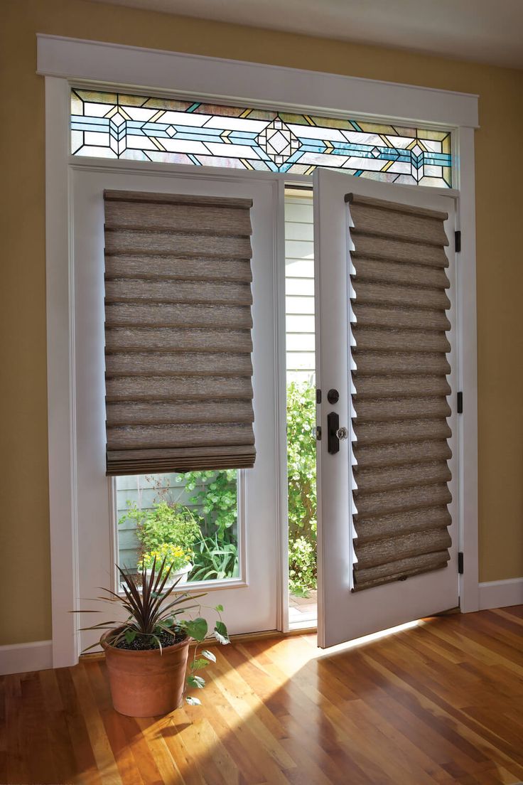 an open window with blinds on it and a potted plant next to the door