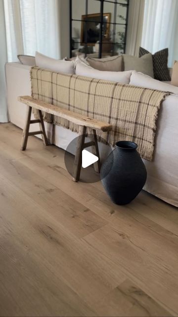 a living room filled with furniture and a wooden bench next to a large white couch