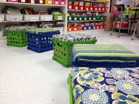 colorful storage bins are lined up in a room with bookshelves and shelves