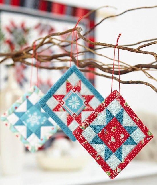 two quilted ornaments hanging from a tree branch