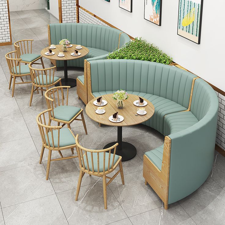 an overhead view of a restaurant with green booths and round tables in the center, surrounded by blue chairs