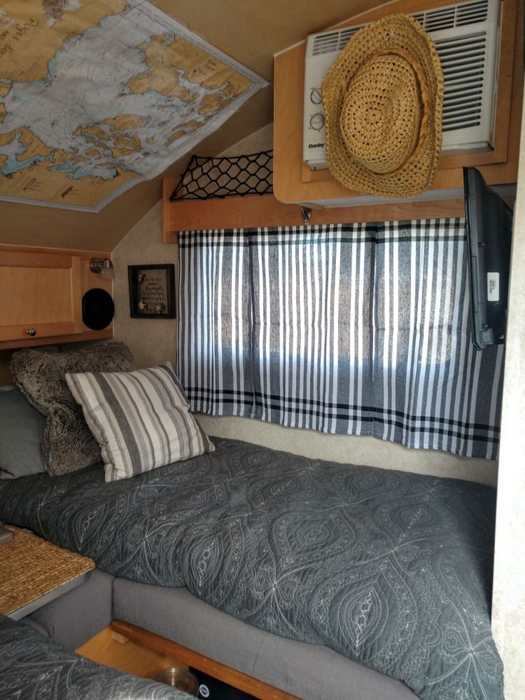 a bedroom with a bed, window and air conditioner in the corner next to it