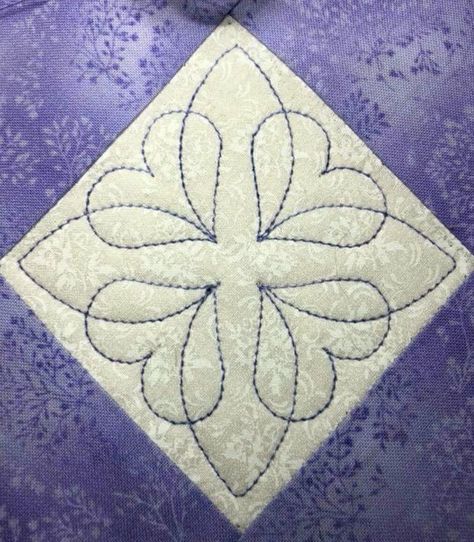 a close up of a purple and white quilt