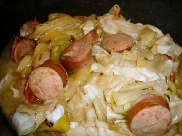 sausages, onions and peppers cooking in a pan