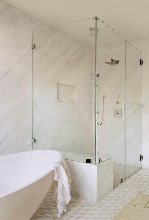 a white bath tub sitting next to a walk in shower