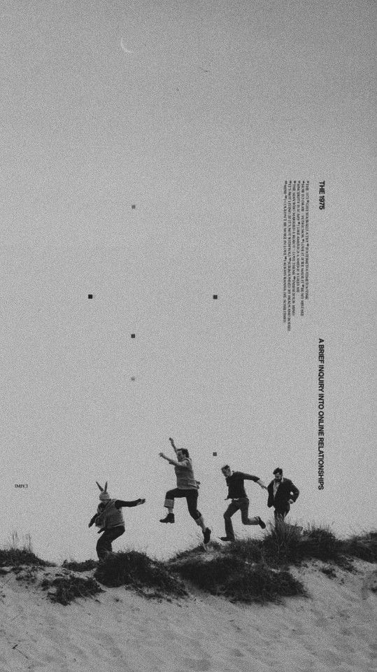 black and white photograph of four people jumping in the air on top of a hill