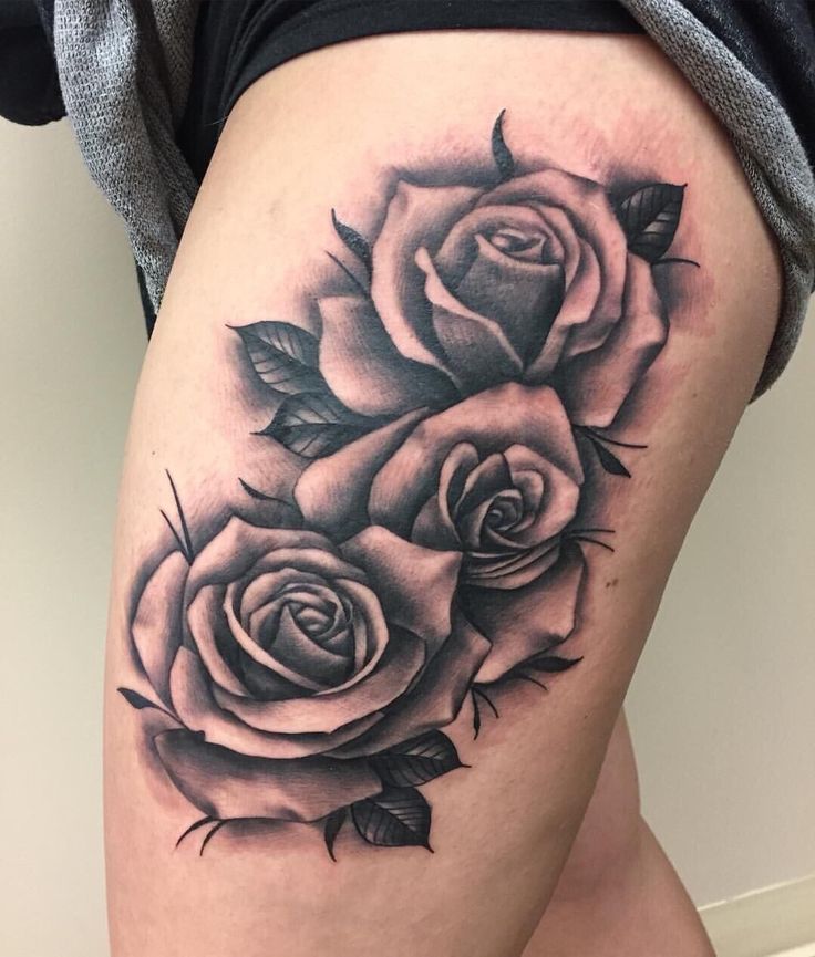 a woman's thigh with three roses tattooed on the leg and one flower in the middle