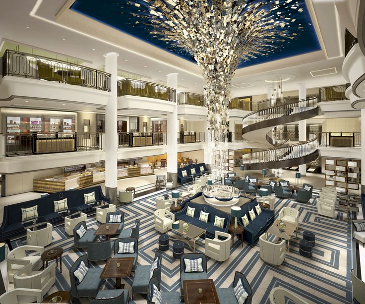 the interior of a large hotel lobby with blue and white carpeting, chandelier and seating