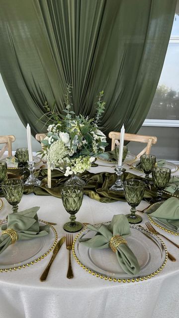 the table is set with silverware and green napkins