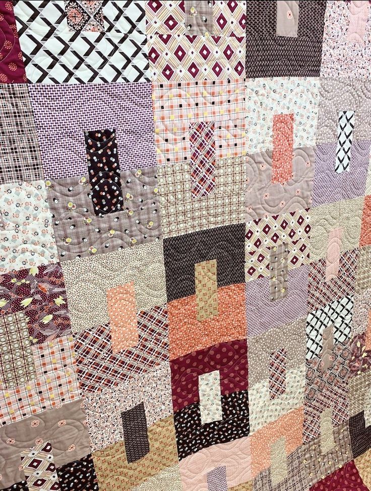 a close up of a quilt with many different colors and shapes on it's surface