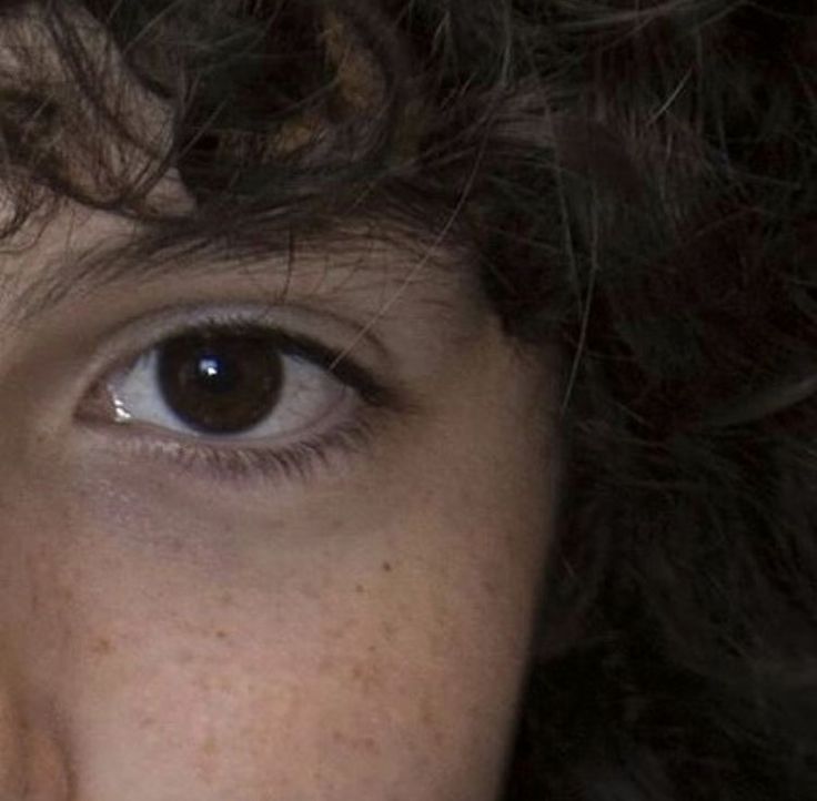 a close up of a person with freckles on her face and brown eyes