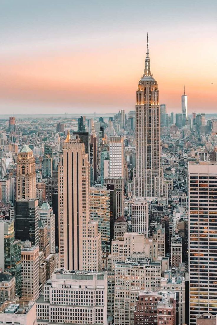 an aerial view of new york city with skyscrapers in the background at sunset or sunrise