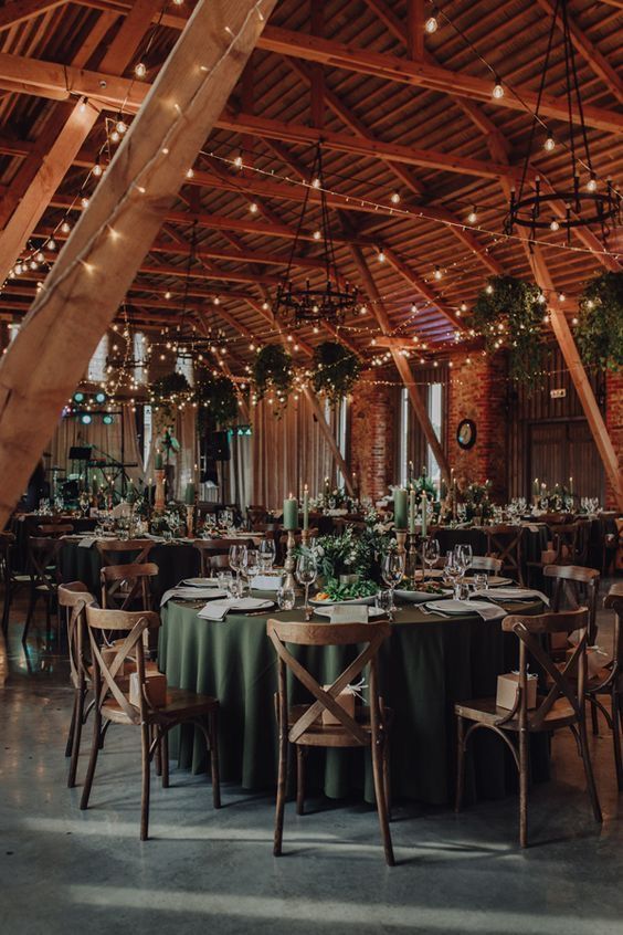 the inside of a barn with tables and chairs set up for an elegant wedding reception