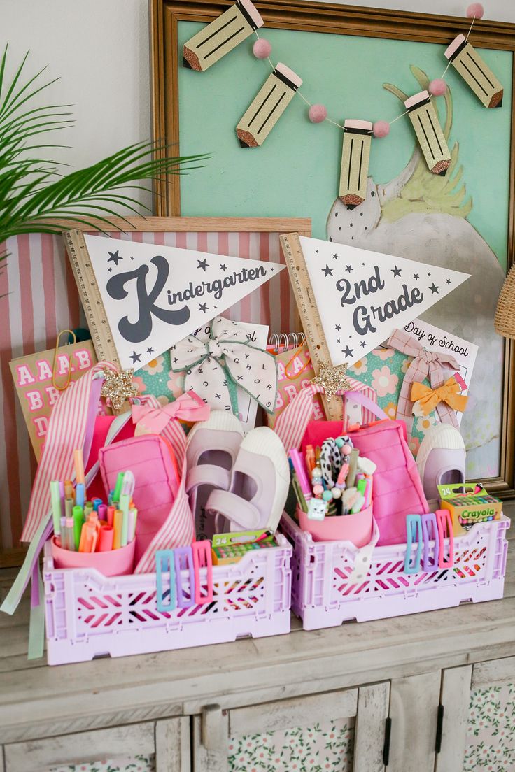 two baskets filled with birthday decorations on top of a wooden table next to a mirror