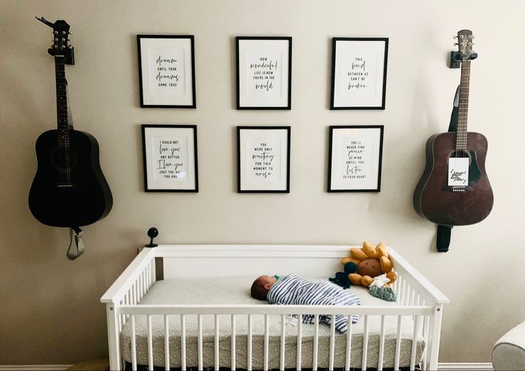 a baby is sleeping in his crib with guitars on the wall behind him and photos above them