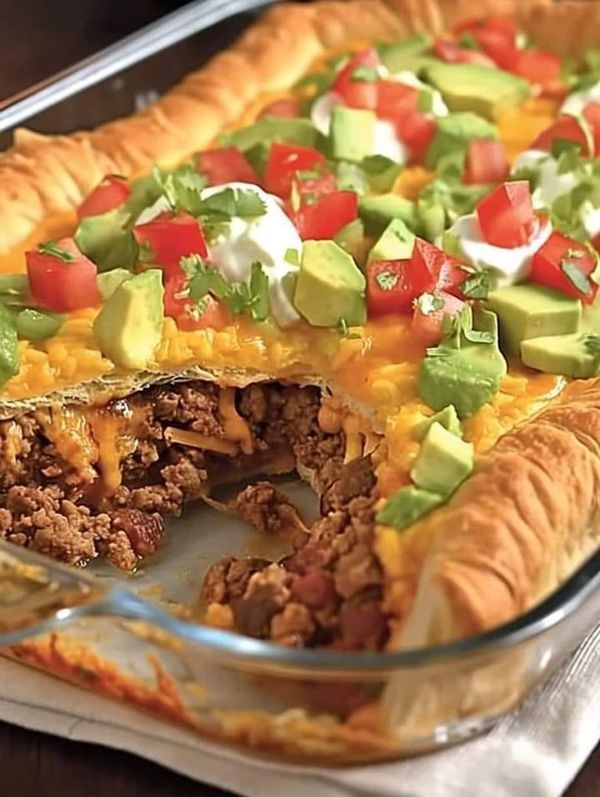 a casserole dish filled with meat, cheese and veggie toppings