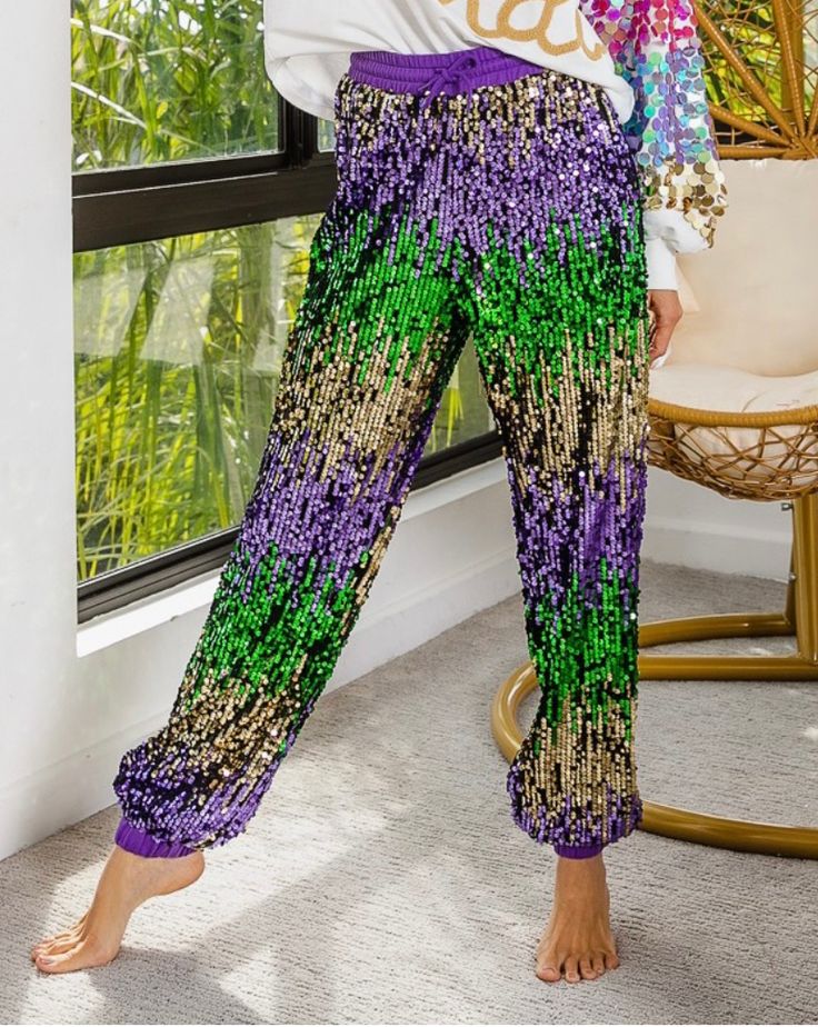 Mardi Gras Sequin joggers.  This Mardi Gras Sequin Pants    will have you so cute for all of the parades y’all!   Oversized fit  💜💚 💛THIS PREORDER SHIPS MID DECEMBER    📌  𝗧𝗛𝗘𝗥𝗘  𝗔𝗥𝗘  𝗡𝗢  𝗖𝗔𝗡𝗖𝗘𝗟𝗟𝗔𝗧𝗜𝗢𝗡𝗦   𝗢𝗡   𝗣𝗥𝗘𝗢𝗥𝗗𝗘𝗥  𝗜𝗧𝗘𝗠𝗦 ! 𝗪𝗲  𝗽𝘂��𝗿𝗰𝗵𝗮𝘀𝗲  𝘁𝗵𝗲𝘀𝗲   𝗶𝘁𝗲m𝘀  𝗳𝗿𝗼𝗺  𝗼𝘂𝗿  𝗩𝗲𝗻𝗱𝗼𝗿  𝘄𝗵𝗲𝗻  𝘆𝗼𝘂𝗿   𝗼𝗿𝗱𝗲𝗿  𝗶𝘀   𝗽𝗹𝗮𝗰𝗲𝗱 . Diy Mardi Gras Pants, Purple Sequin Pants, Mardi Gras Pants Diy Cajun, Mardi Gras Sequin Skirt, Mardi Gras Shorts, Sequin Pants, Mardi Gras, Oversized Fits, Boutique