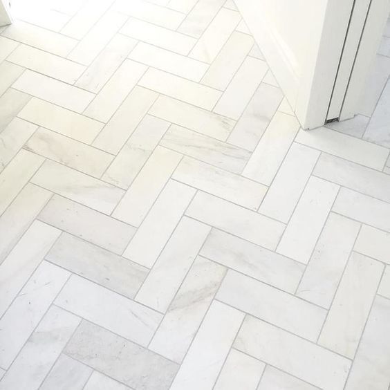 a bathroom with a white toilet and tiled floor