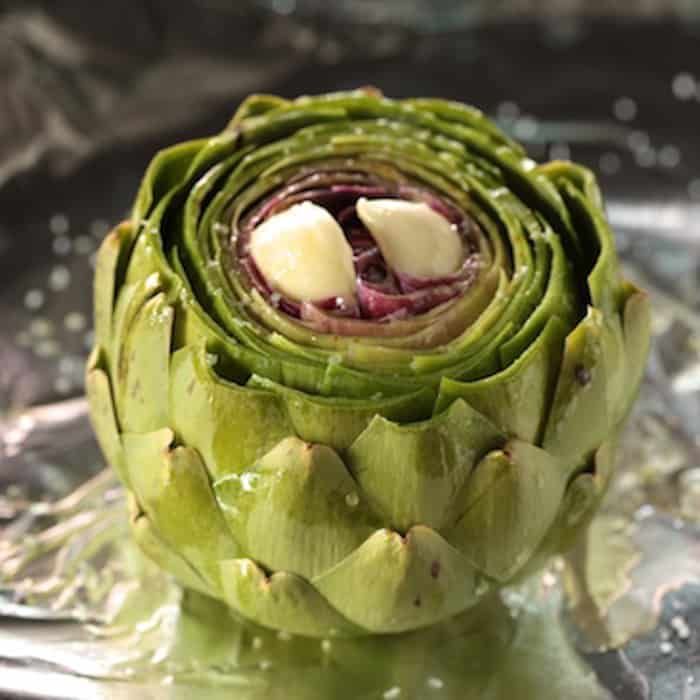 an artichoke is sitting on top of ice in the water and has been cut into pieces