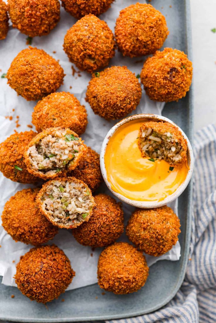 some food is sitting on a tray and ready to be eaten with dipping sauce in the middle