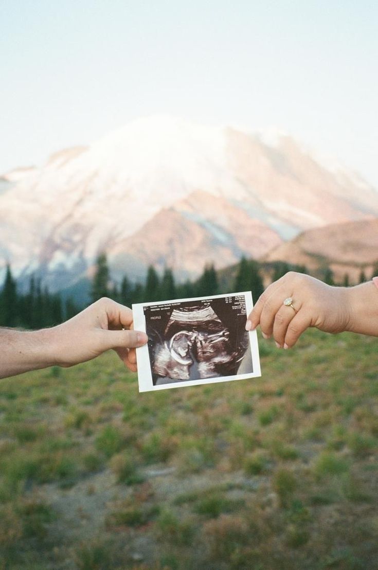 two people holding up an x - ray in front of a mountain