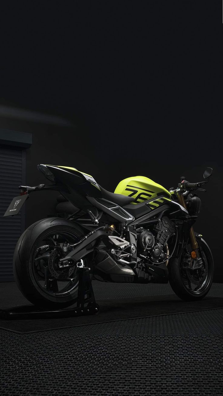 a yellow and black motorcycle parked in the dark