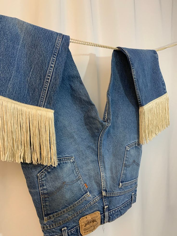 "Vintage 80's medium-dark wash perfectly broken in Levi's coveted fit 517's with added 6\" creme fringe. Designed and handmade in house as part of our collaboration with our friends, Tame. Marked 36/ modern m/l  or 34 and fits 32-34\" waists best. Measures 35\" around waist, 41.5\" around hips, 12\" rise, 30\" inseam with fringe included. *You can also custom order your size/color<3 Shop Journal Studios designs and pieces are handmade, handcrafted or upcycled by us in house. For remade vintage i Repurposed Levi Jeans, Denim Blue Jeans With Fringe, Denim Blue Fringe Jeans, Fringe Medium Wash Denim Jeans, Medium Wash Fringe Jeans, Cutoff Fringe Denim Jeans, Denim Jeans With Fringe Cutoff, Cutoff Denim Jeans With Fringe, Fringe Cutoff Denim Jeans