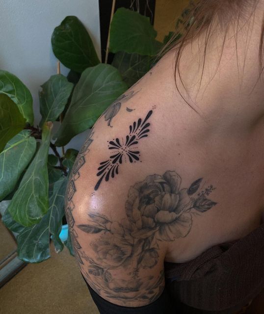 a woman with a flower tattoo on her shoulder