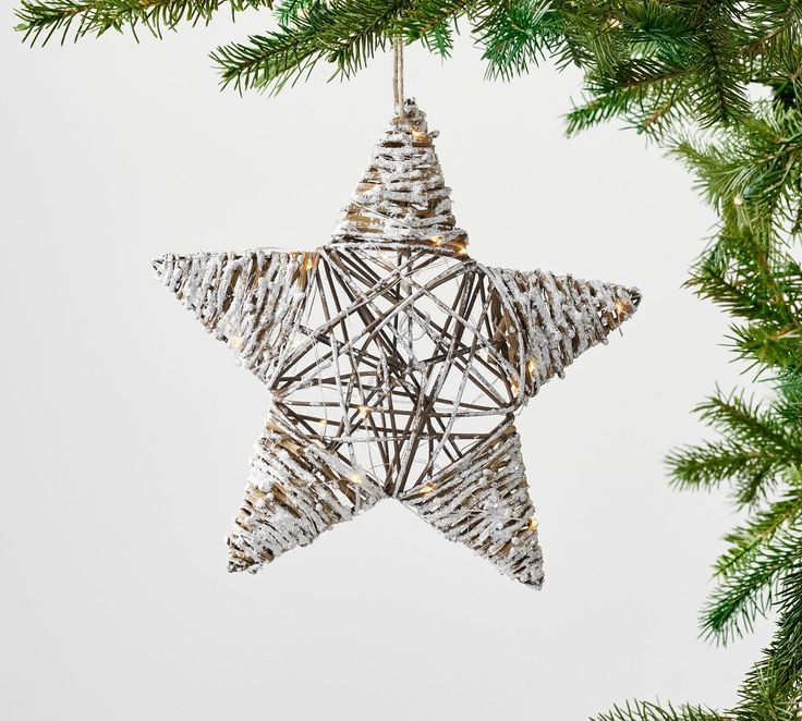 a star ornament hanging from a christmas tree