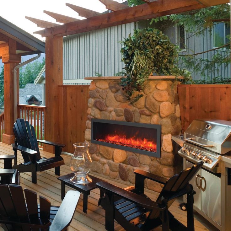 an outdoor patio with chairs, table and fire place in the center is surrounded by wood planks