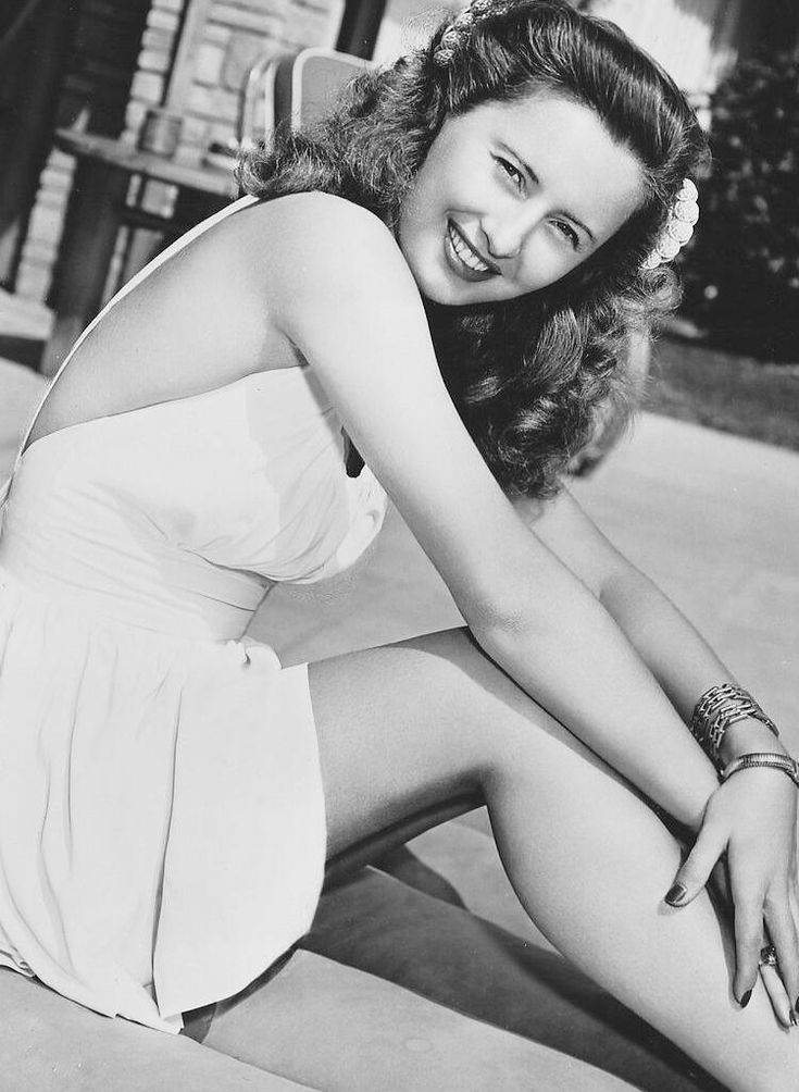 a black and white photo of a woman sitting on the ground