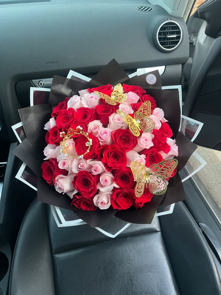 a bouquet of red and pink roses in the back seat of a car