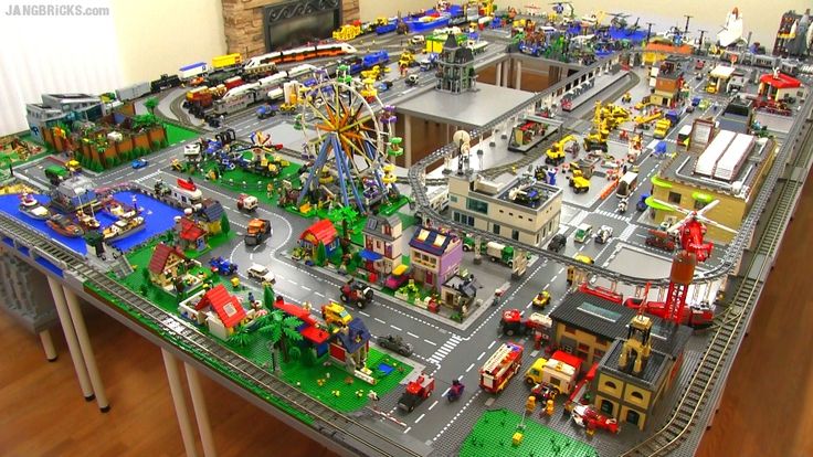 a table that has many legos on it and is full of cars, trucks, and people