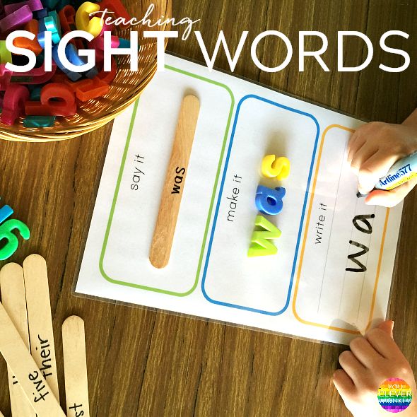 two children are playing with letters and numbers on a table next to some wooden spoons