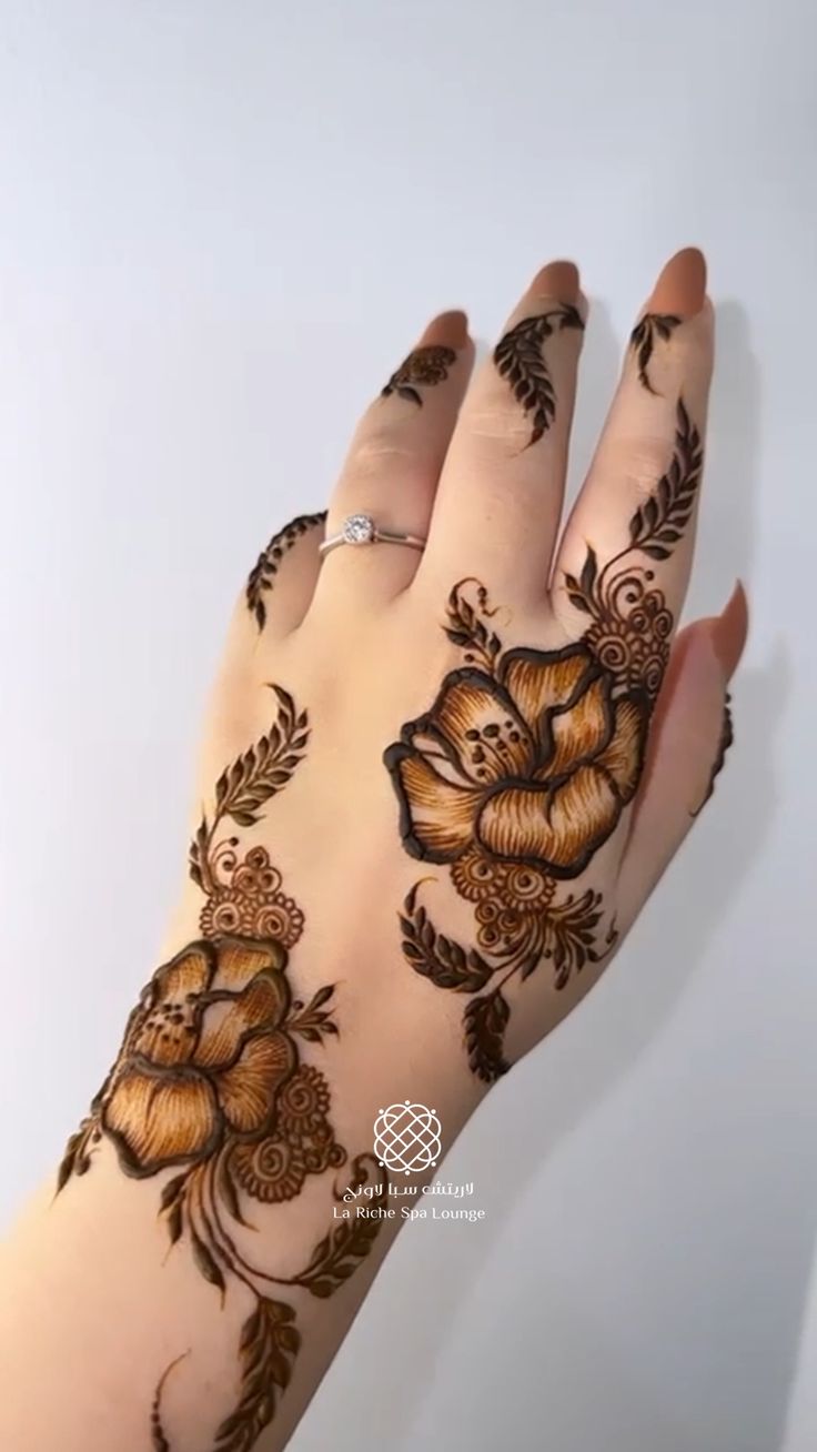 a woman's hand with henna tattoos on it