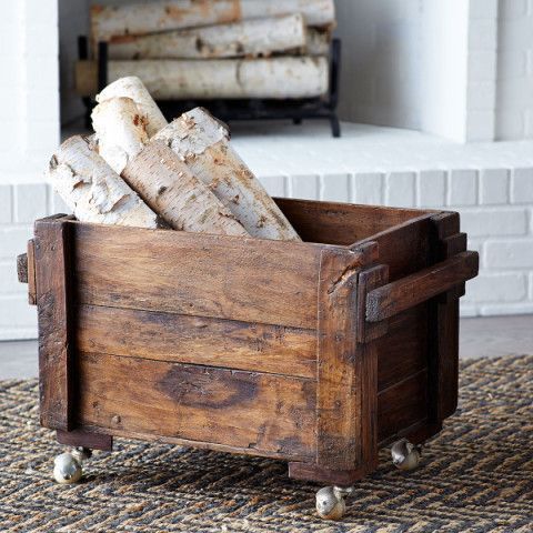 a wooden crate filled with logs sitting on top of a rug