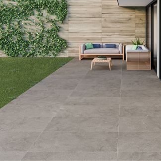 an outdoor living area with concrete flooring and walls covered in greenery, including plants