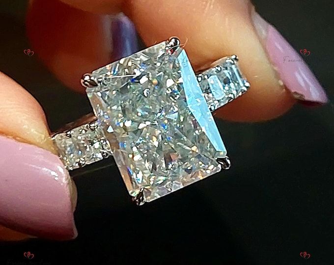 a woman's hand holding an engagement ring with a large diamond in the center