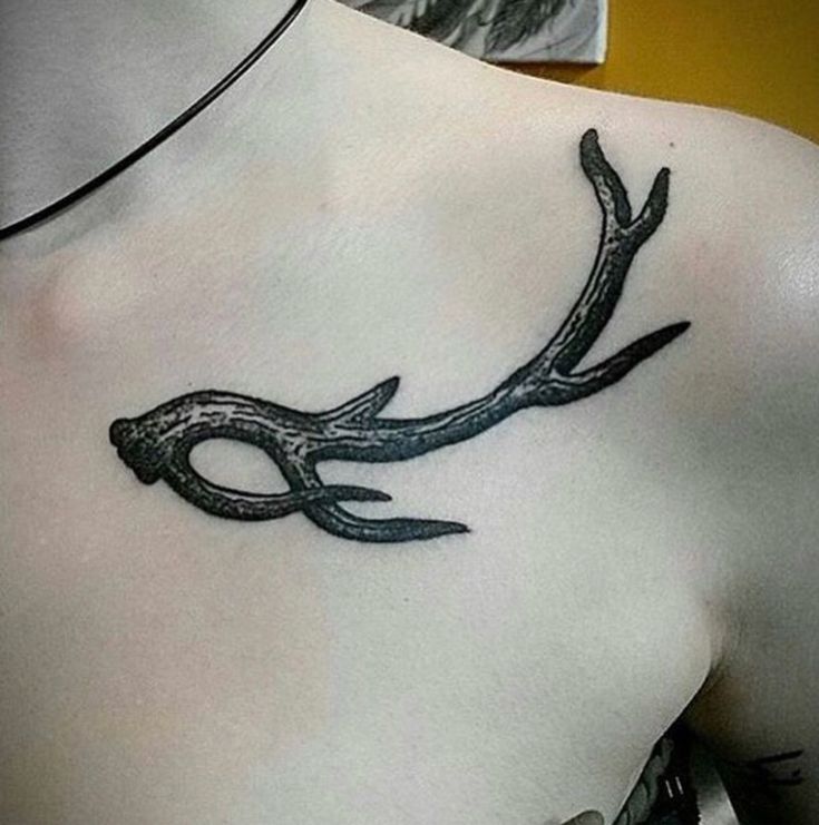 a man with a tattoo on his chest has a deer's antelope